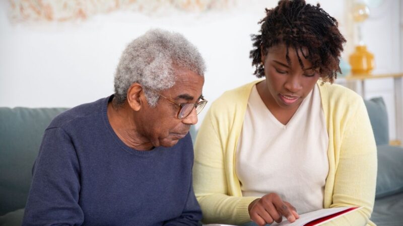 Carer reading a book with a man