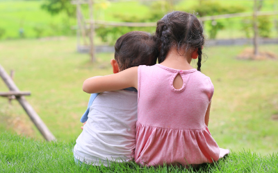 back view of a young girl and a young boy hugging