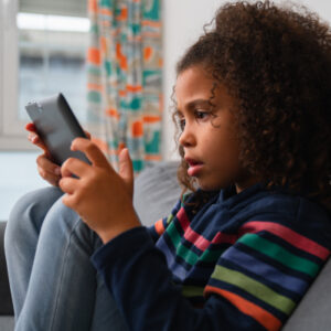 photo of young girl playing on her phone