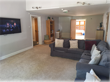 The lounge area with sofas and a TV on the wall