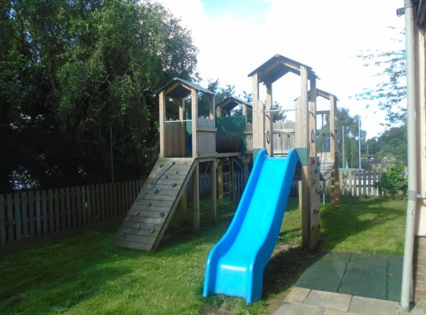 Wooden climbing frame with slide in the garden.