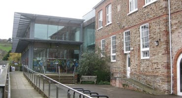 photo of the mansion totnes,modern building with large glass windows and a hand rail and path for ease of access