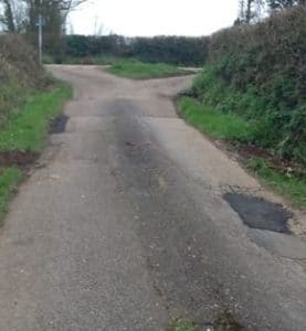 country road with pot holes rapired with tarmac