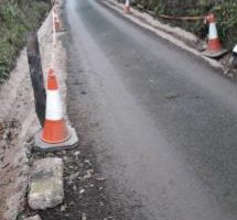 traffic cones and tape situated along roadside at Luppitt