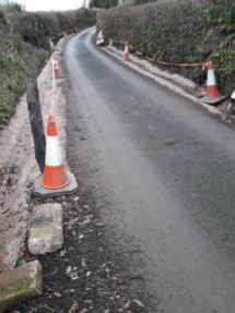 traffic cones and tape situated along roadside at Luppitt