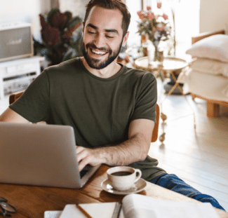 Man smiling using a laptop at home