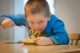 boy eating a bowl of pasta