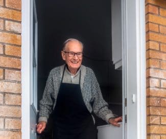 elderly man stood in doorway