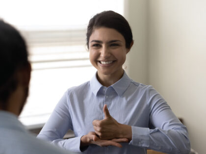 Smiling young Indian woman who is deaf using sign language
