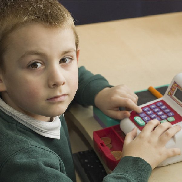 young boy playing with a till (Devon's SEND Local Offer)