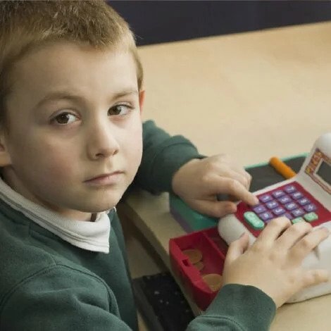 young boy playing with a till