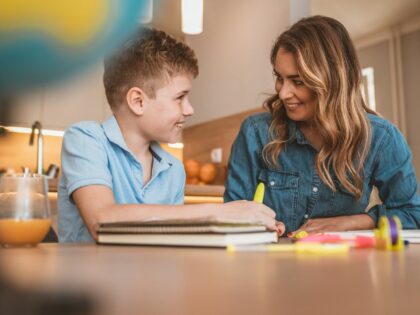 a teacher and a school age boy working together in a classroom