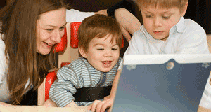 Woman and two boys looking at a laptop