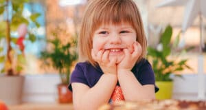 A young girl sat at a table smiling