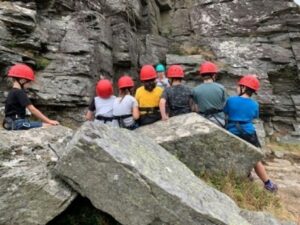 Children participating in an outdoor activity near some rocks