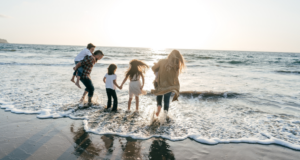 a family of five playing in the sea at sunset