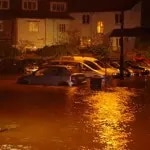 Flooded street with cars at night, Buckfastleigh