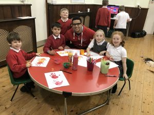 Dan and school children making handprints in paint