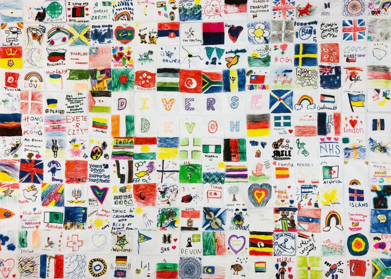 A patchwork flag made up of colourful images each depicting a place or country or word about respect and diversity.