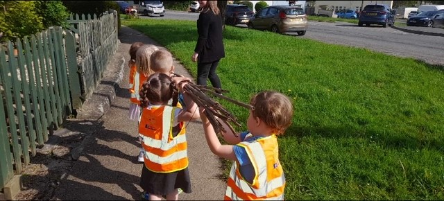 Children from EarlyBirds nursery carrying some sticks.