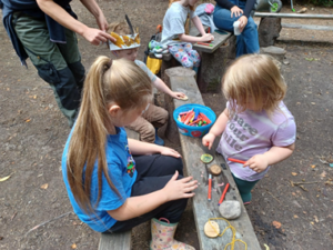 Children outside with crayons and stones.
