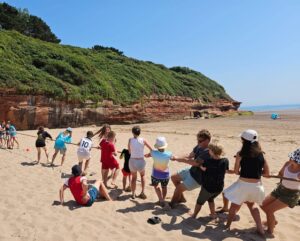 Children on the beach playing 'tug of war'.