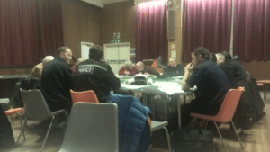 Photo of individuals around table discussing community emergency plan