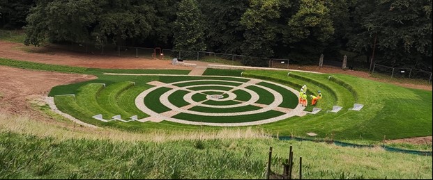 A colour photograph of a grassy amphitheatre with a spiral path in the middle.