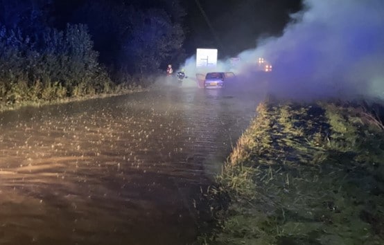 A photo of Seaton Fire Crew in attendance of a car stranded in flood water.