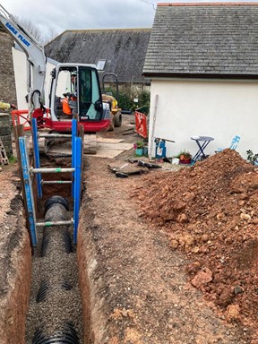 A colour photograph of flood improvement works being carried out in a trench.