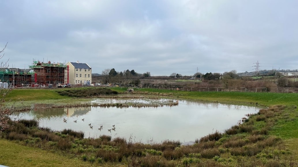 A photo of a attenuation basin filled with water and with grass around the outside.