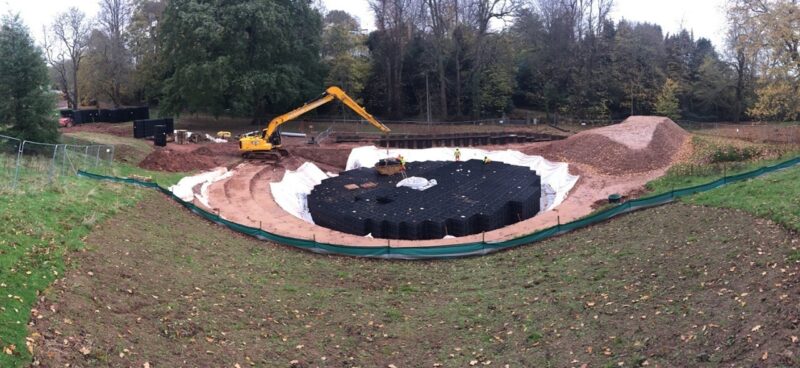 Construction area with a digger installing water storage crates which will then be buried underground