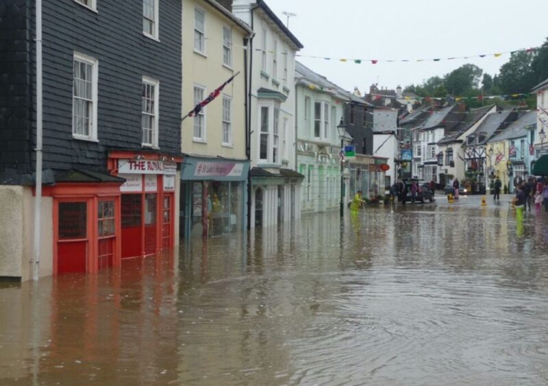 Flood water on Modbury high street, water depth reaches almost halfway up the shop window fronts