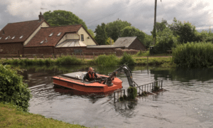 Ranger Craig Saunderson operating the Weedboat clearing weed from the canal