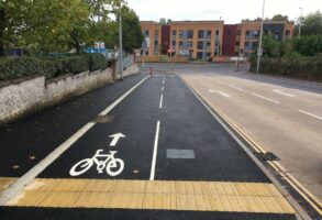 Photo of cycle facility similar to proposed Rifford Road scheme, with two-way cycle track separated from pedestrians using flush kerb