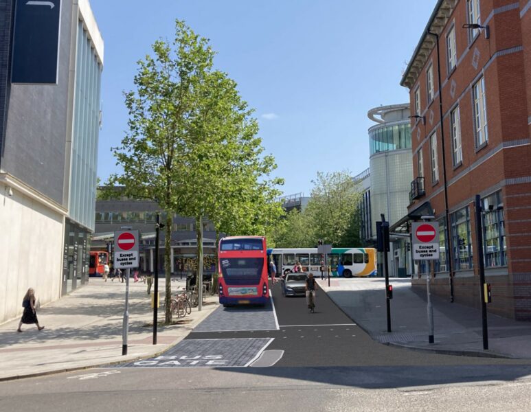 : A visualisation of the proposed New North Road bus gate and bus lane between Waterstones and John Lewis looking towards Paris Street. The image shows the new no entry except buses and cycles signage on either side of the carriageway as well as the new road surface including the block effect imprint on the bus lane. The image shows a double decker bus and passenger car passing side by side with a cyclist in front of the vehicle. 