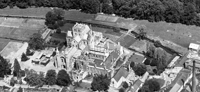 A black and white aerial photograph centred on the church, which is surrounded by monastic buildings and landscaped grounds.