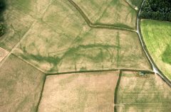 A colour aerial photograph showing dark cropmarks of a rectilinear ditched enclosure