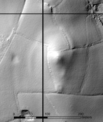 A black and white lidar visualisation of a substantial curvilinear earthwork bank around a hilltop.