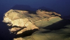 A colour photograph taken from the air, showing the hillfort earthworks as a substantial bank cutting across the promontory of Bolt Tail in 1986