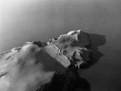 A black and white photograph taken from the air, of the substantial earthwork bank across the promontory at Bolt Tail