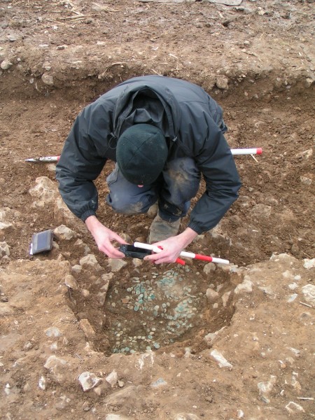 The coin hoard being recoded in its pit