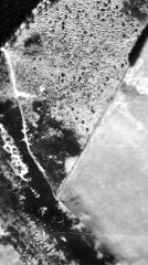 Numerous pits are visible as circular and linear earthworks on this black and white vertical aerial photograph.