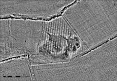 A greyscale image showing a large irregular pit, overlain by narrow parallel linear earthwork banks.