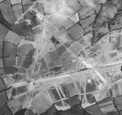 A black and white aerial photograph showing the three airfield runways in a trianguar formation crossing numerous fields. Hedgebanks within this area have been removed and their former position is visible as linear stretches of bare earth.