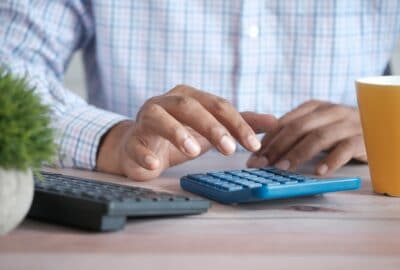 male tapping on a calculator