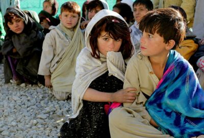 Children from Afghanistan sat on the ground