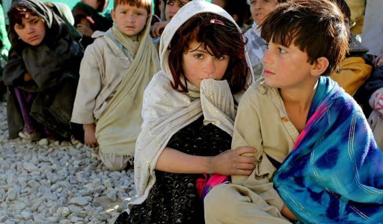 Children from Afghanistan sat on the ground