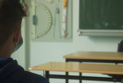 child wearing a face covering in a classroom