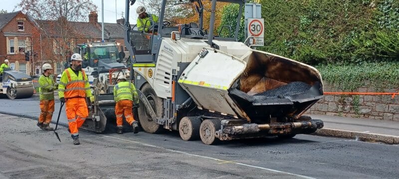 Highway maintenance team laying the top layer of a road in Exeter